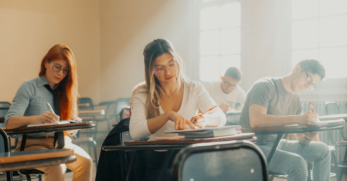 Focused students taking an exam in a sunlit Buenos Aires classroom with a relaxed academic atmosphere.